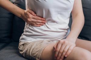 Woman holding stomach | Image credit: Yura Yarema - stock.adobe.com
