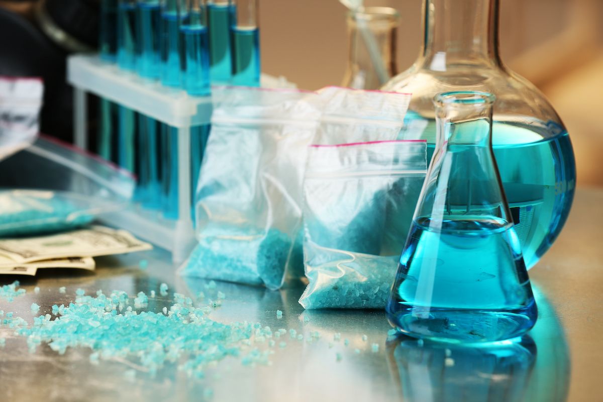 Blue methamphetamine and liquid in flasks on table in laboratory | Image credit: © Africa Studio - stock.adobe.com
