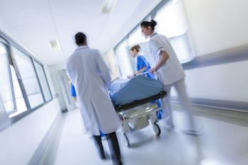 person on a gurney in a hospital being transported by doctors
