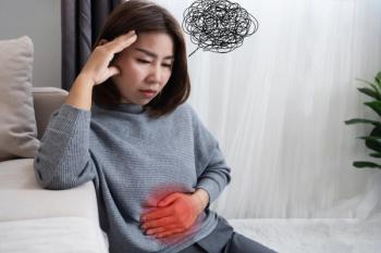 Stressed woman sitting on couch, holding stomach, with scribble thoughts drawn above head | Image credit: doucefleur – stock.adobe.com