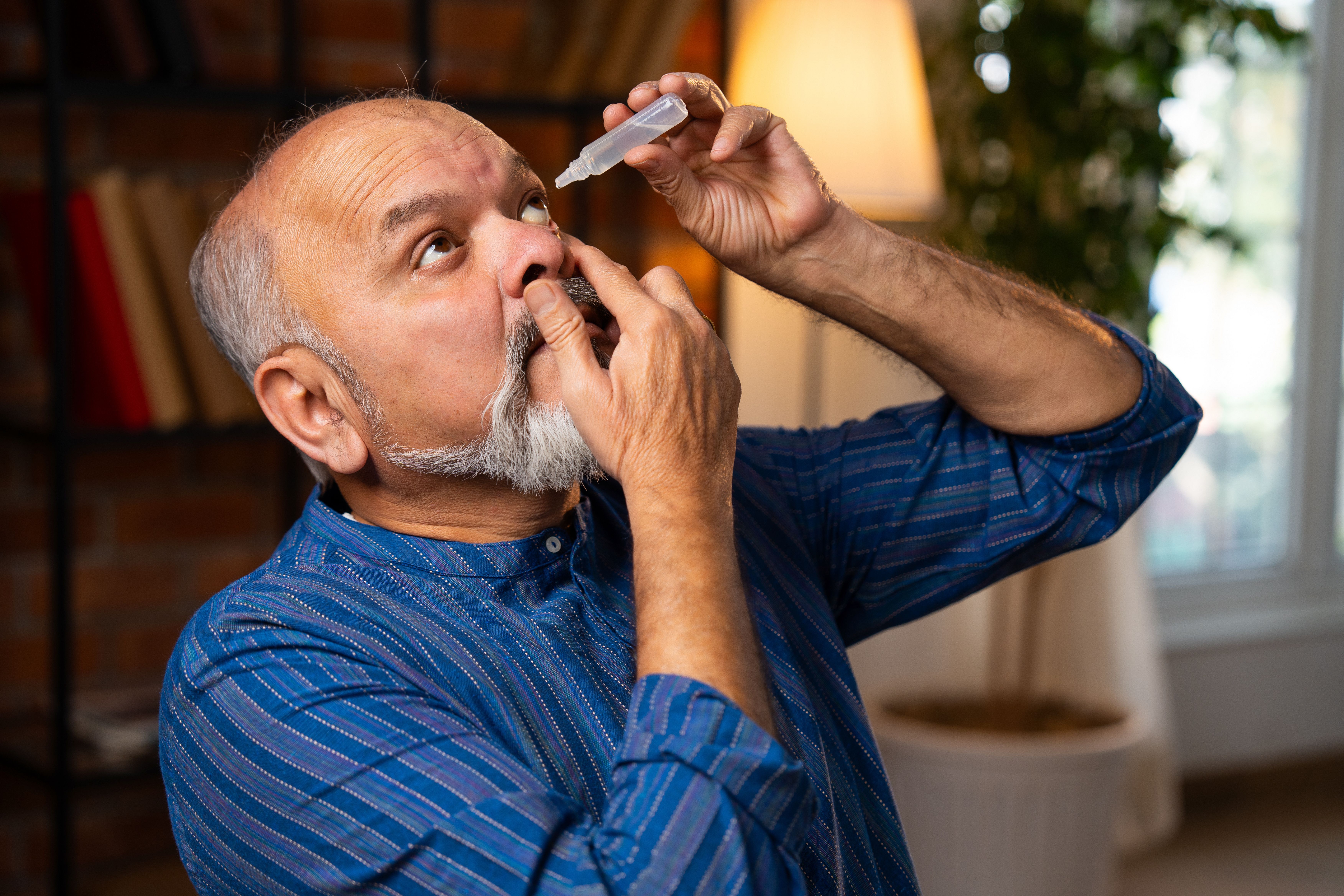 Man applying eye drops | Image credit: StockImageFactory