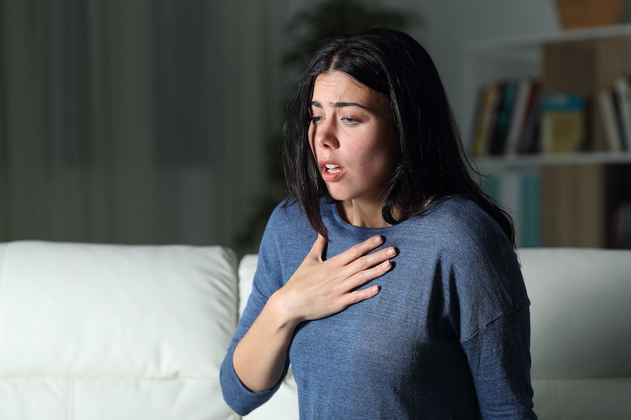 Woman suffering an anxiety attack alone in the night: © Antonioguillem