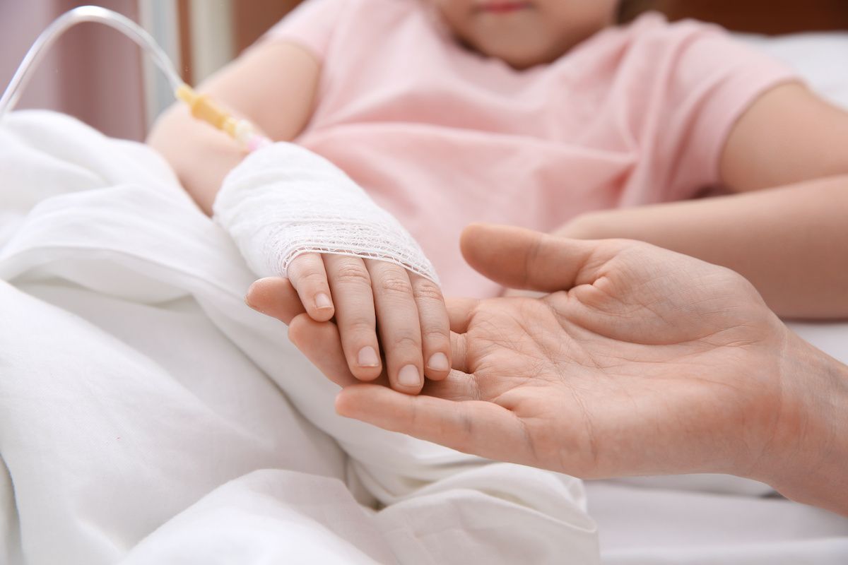 Doctor holding child's hand with intravenous drip | Image Credit: © New Africa - stock.adobe.com