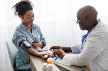 Doctor taking female patient's blood pressure. | Image credit: Prostock-studio – stock.adobe.com