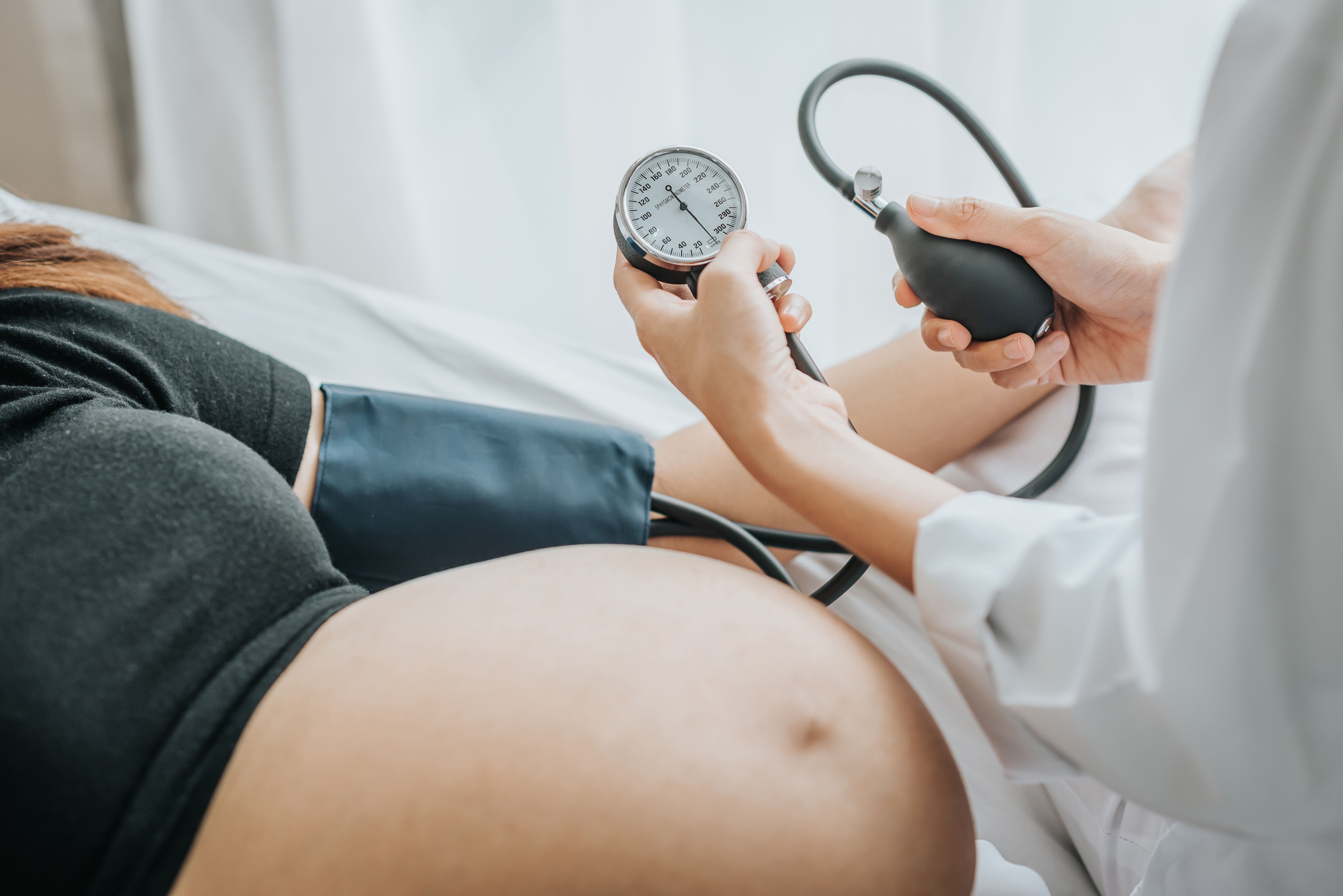 Doctor taking pregnant woman's blood pressure | Image credit: interstid – stock.adobe.com