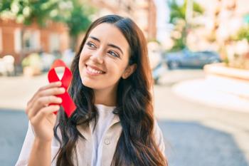 Woman with HIV awareness ribbon | Image credit: Krakenimages.com - stock.adobe.com