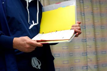 nurse holding and reading binder