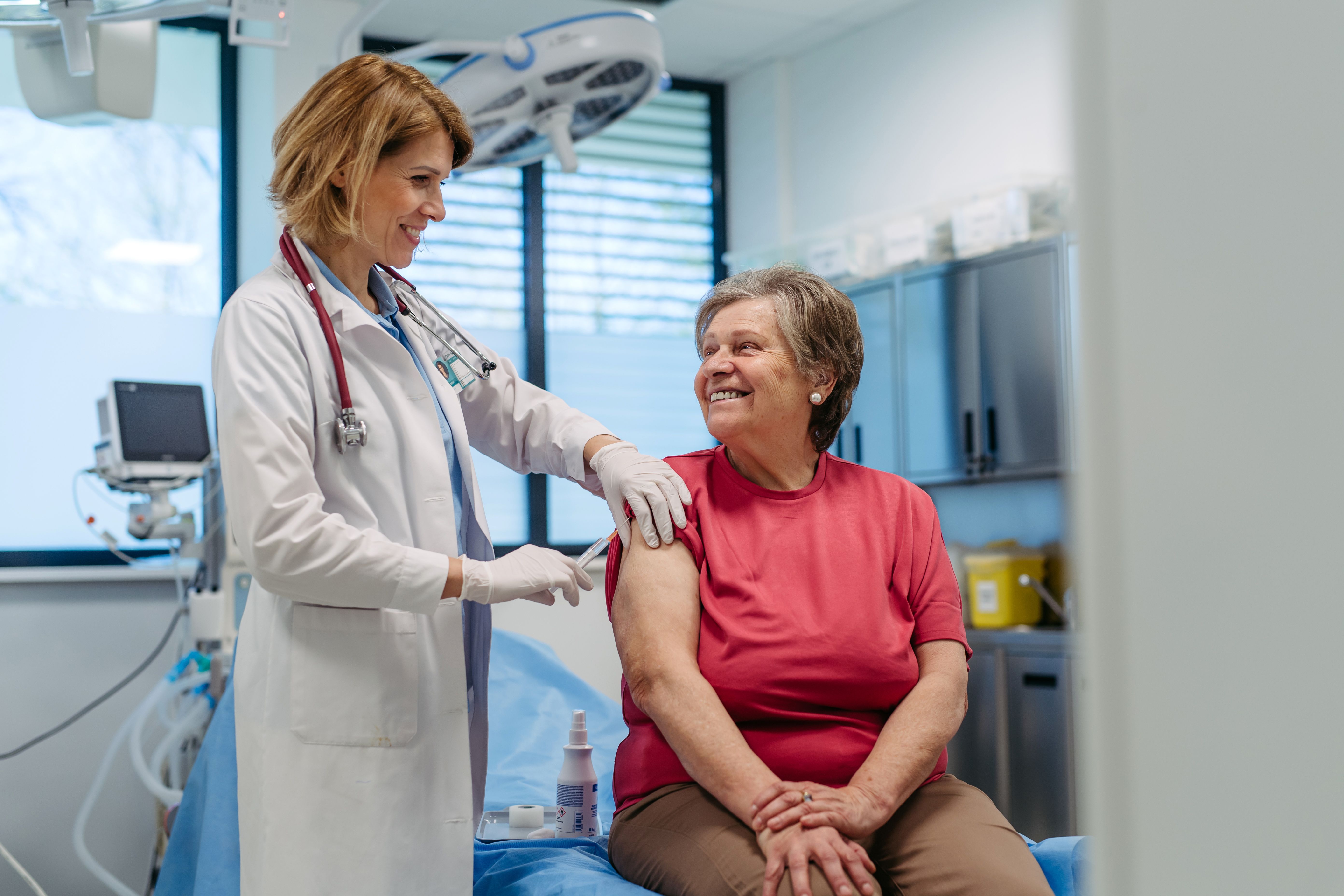 Doctor administering vaccine to older woman | Image credit: Halfpoint – stock.adobe.com