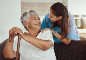 Older woman sitting with a caregiver leaning over from behind. | Image Credit:Jade Maas/peopleimages.com - AdobeStock_532179571.jpeg