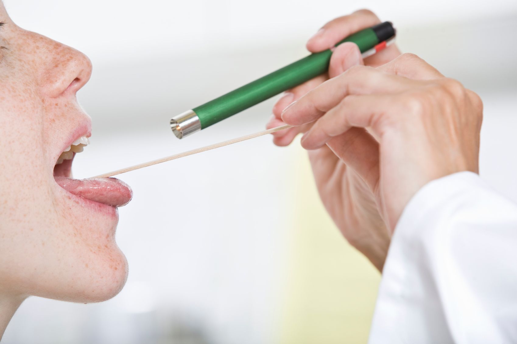 Doctor checking patient's throat