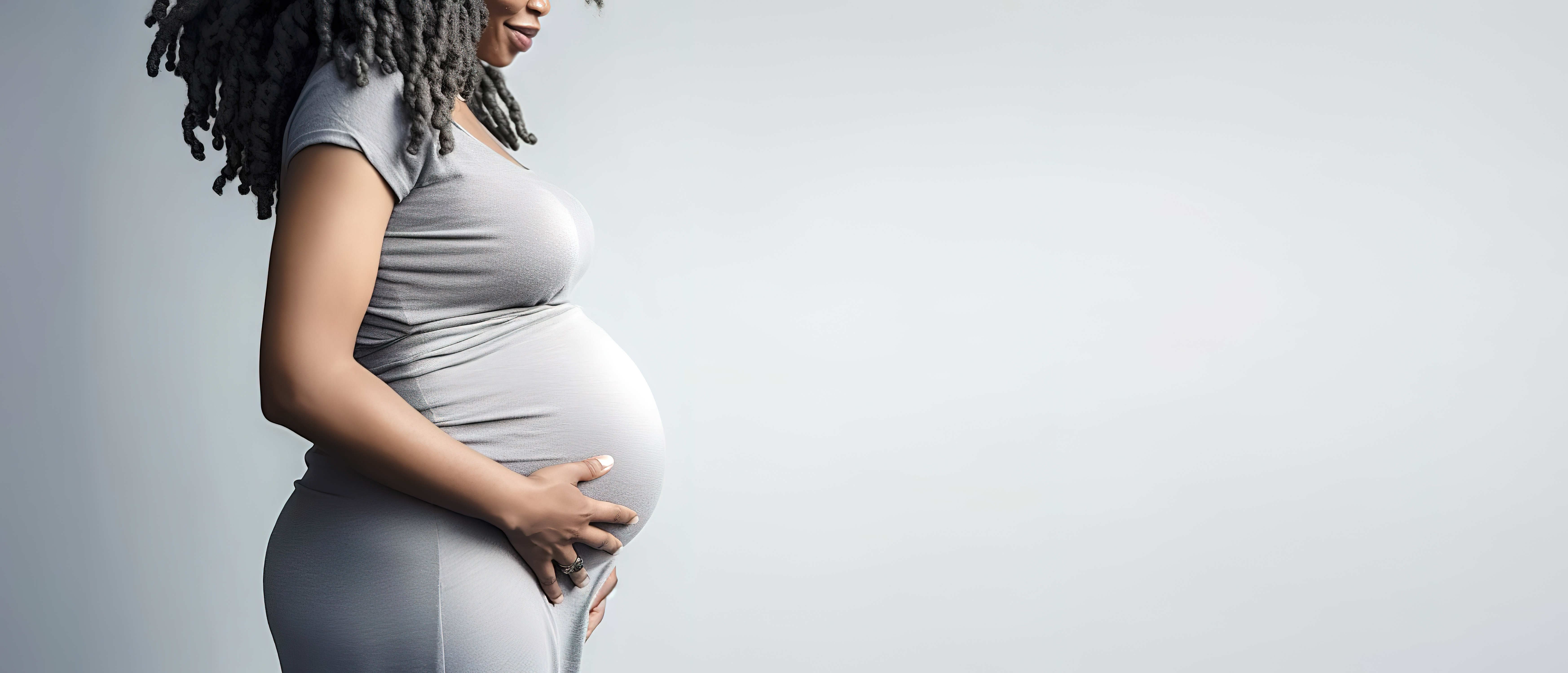 banner pregnant black woman in grey dress holds hands on big belly Image Credit: Copyright Jim1786 stock.adobe.com