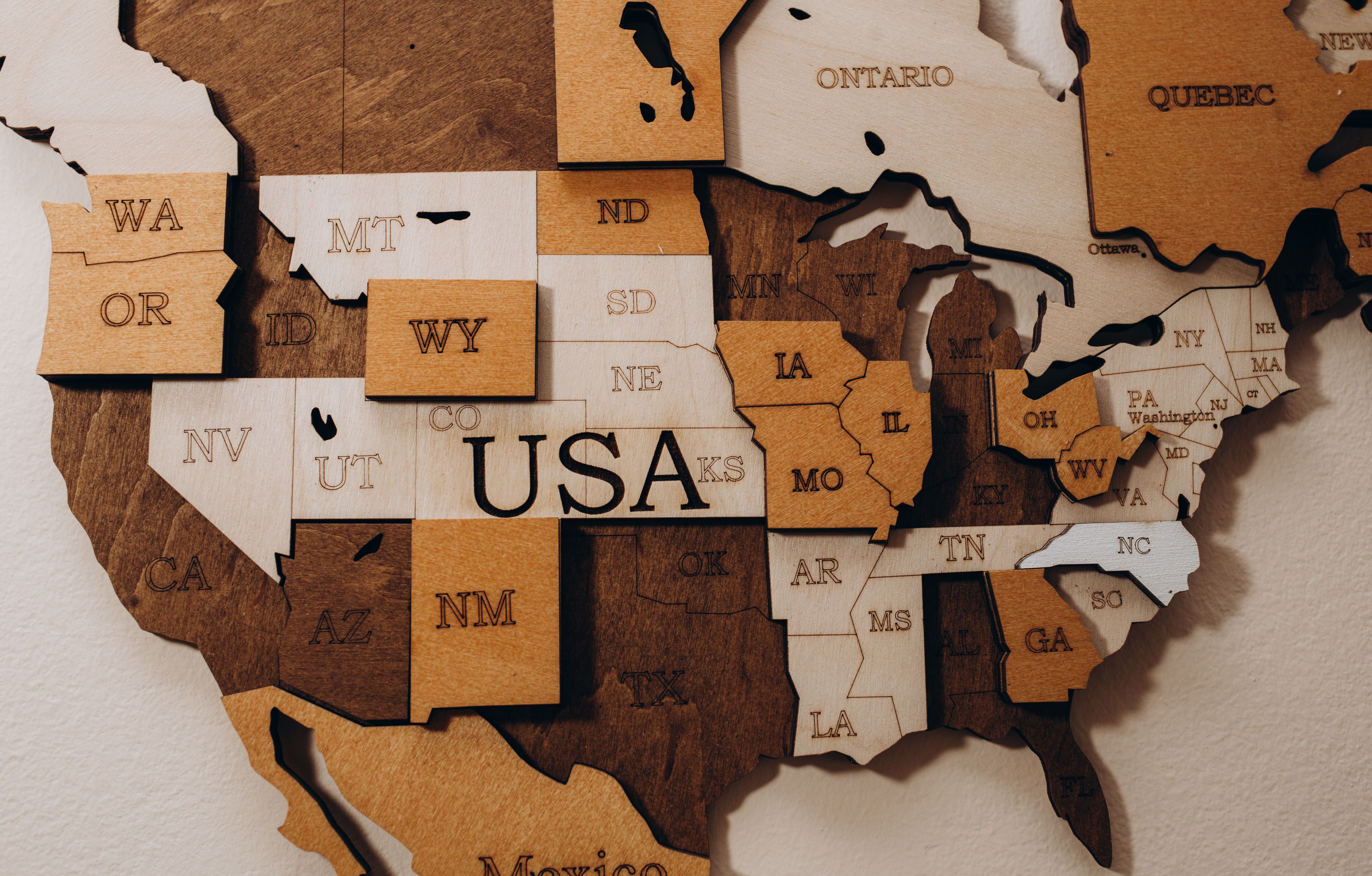 Made in the USA wood sign of US wood map with stars on weathered whitewash wood | Image Credit: Roman - stock.adobe.com.