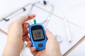 Hand holding a blood glucose meter measuring blood sugar, the background is a stethoscope and chart file | Image Credit: xb100 – stock.adobe.com