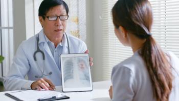 Doctor showing patient x-ray of lung cancer. | Image credit: Nattakorn – stock.adobe.com