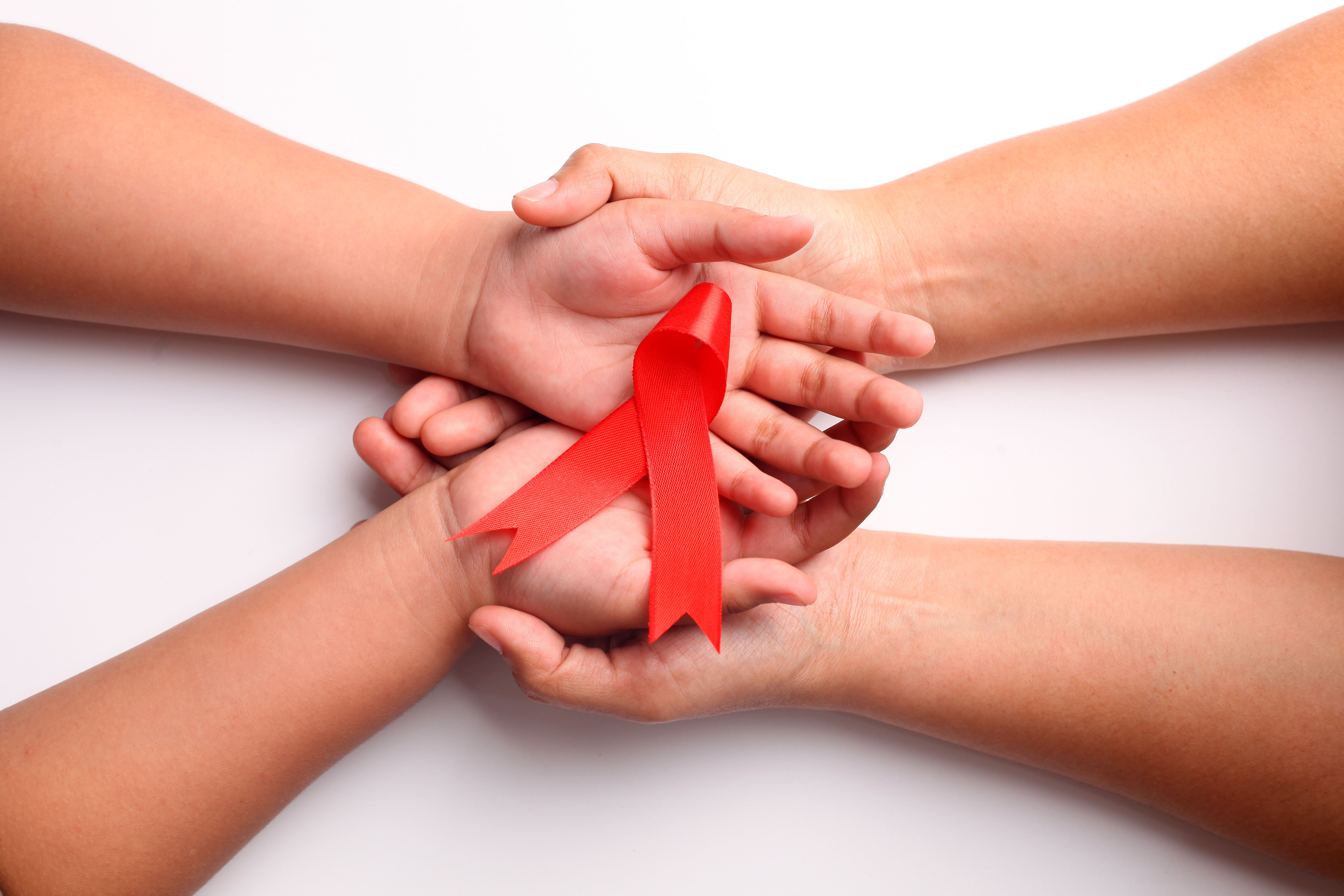 Woman and child holding red ribbon | Image credit: ArvStd - stock.adobe.com