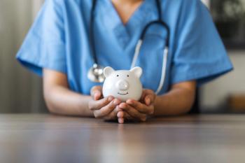 Clinician holding piggy bank | Image Credit: Dee Karen - stock.adobe.com