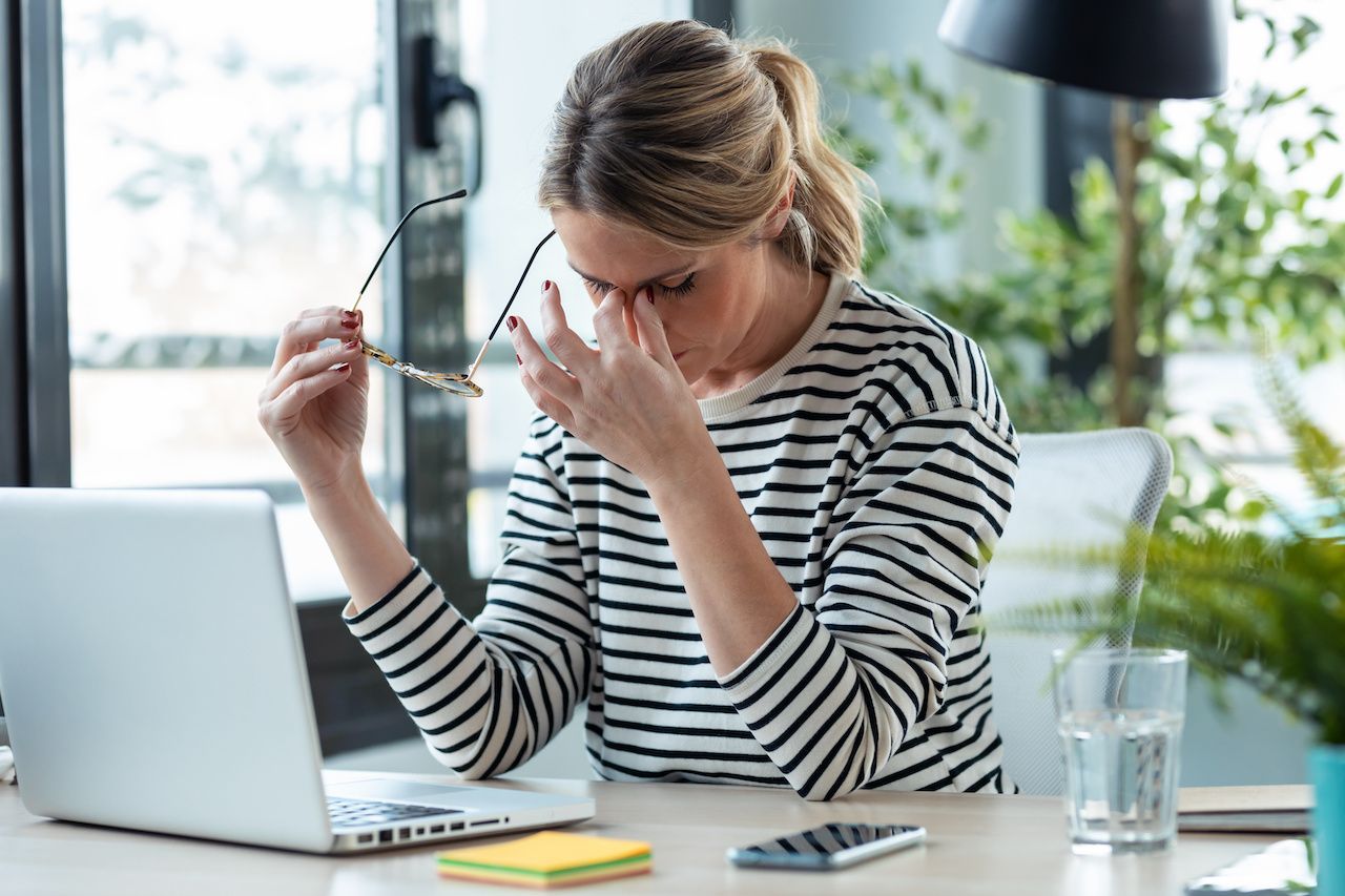 Stressed mature business woman looking worried, tired and overwhelmed while working with laptop on a desk in the office at home: © nenetus - stock.adobe.com