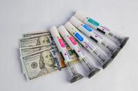 Weight loss drug injectable pens next to 100 dollar bills | Image credit: Mohammed – stock.adobe.com