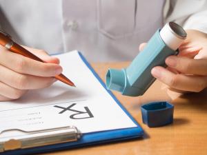 asthma inhaler and writing medical prescription on rx form for treatment asthma | Orawan - stock.adobe.com