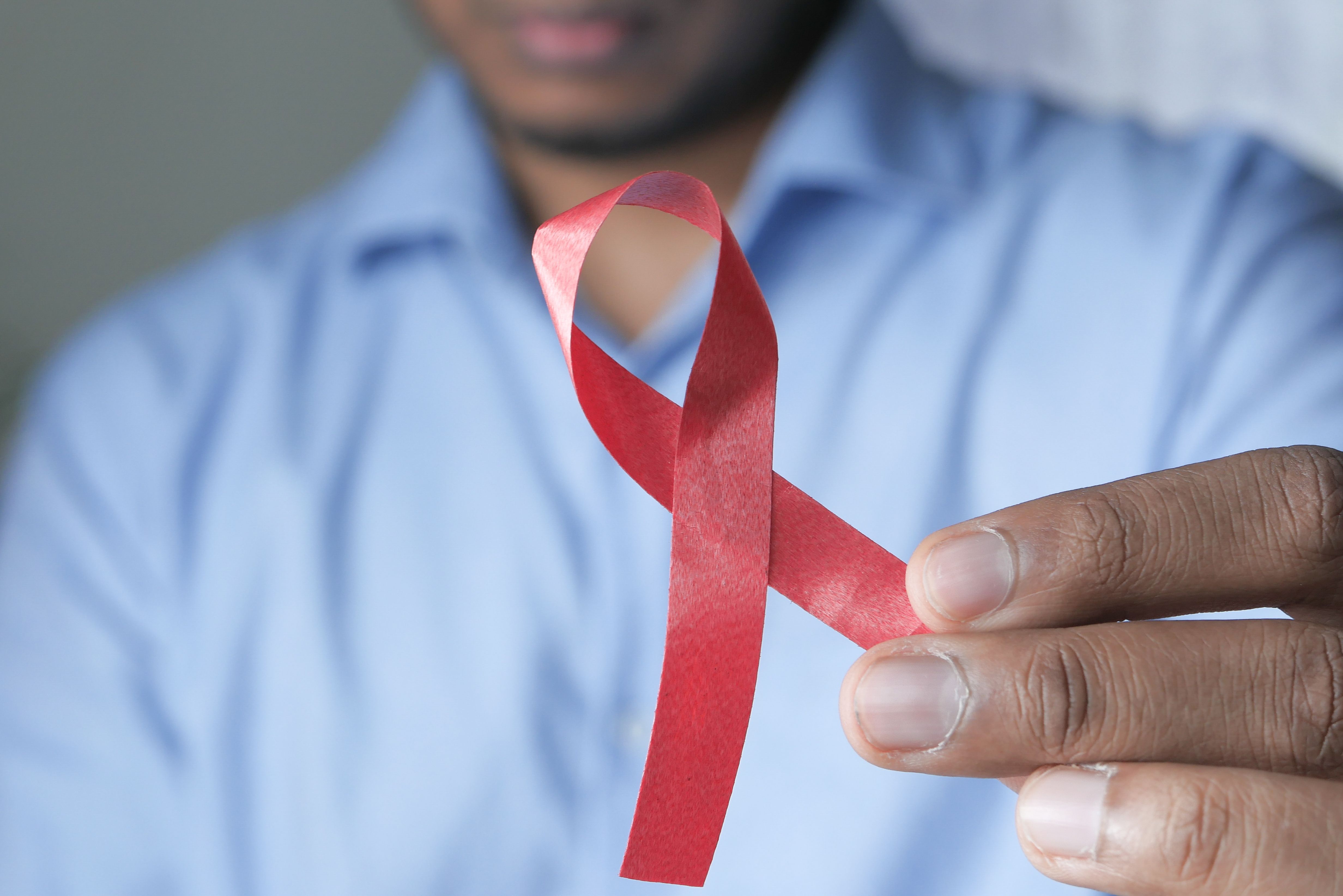 Black man holding red ribbon | Image credit: Towfiqu Barbhuiya - stock.adobe.com