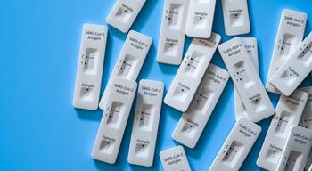 Mass testing for Covid-19 / SARS-CoV-2 infection concept: Several rapid antigen test kits. One kit in the middle showing a positive result (two lines visible) | Image Credit: Andreas Prott - stock.adobe.com