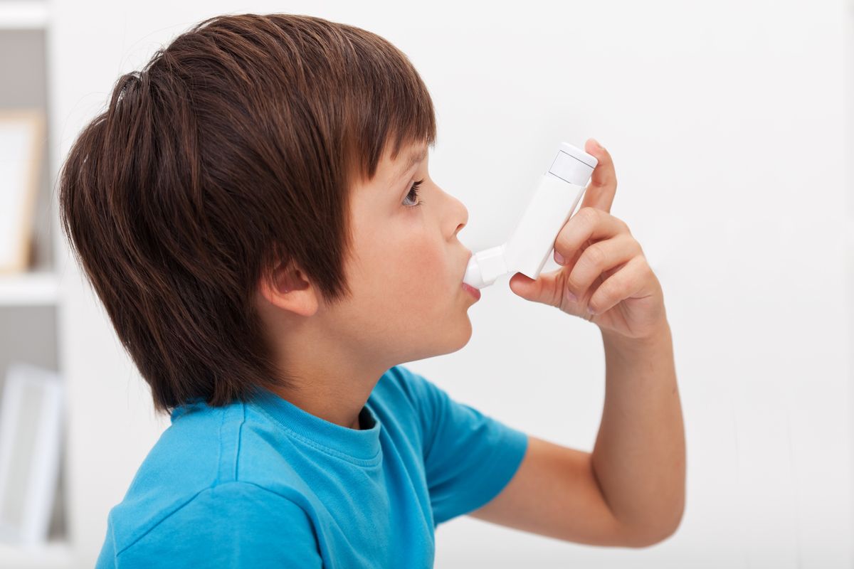 Child using inhaler for asthma