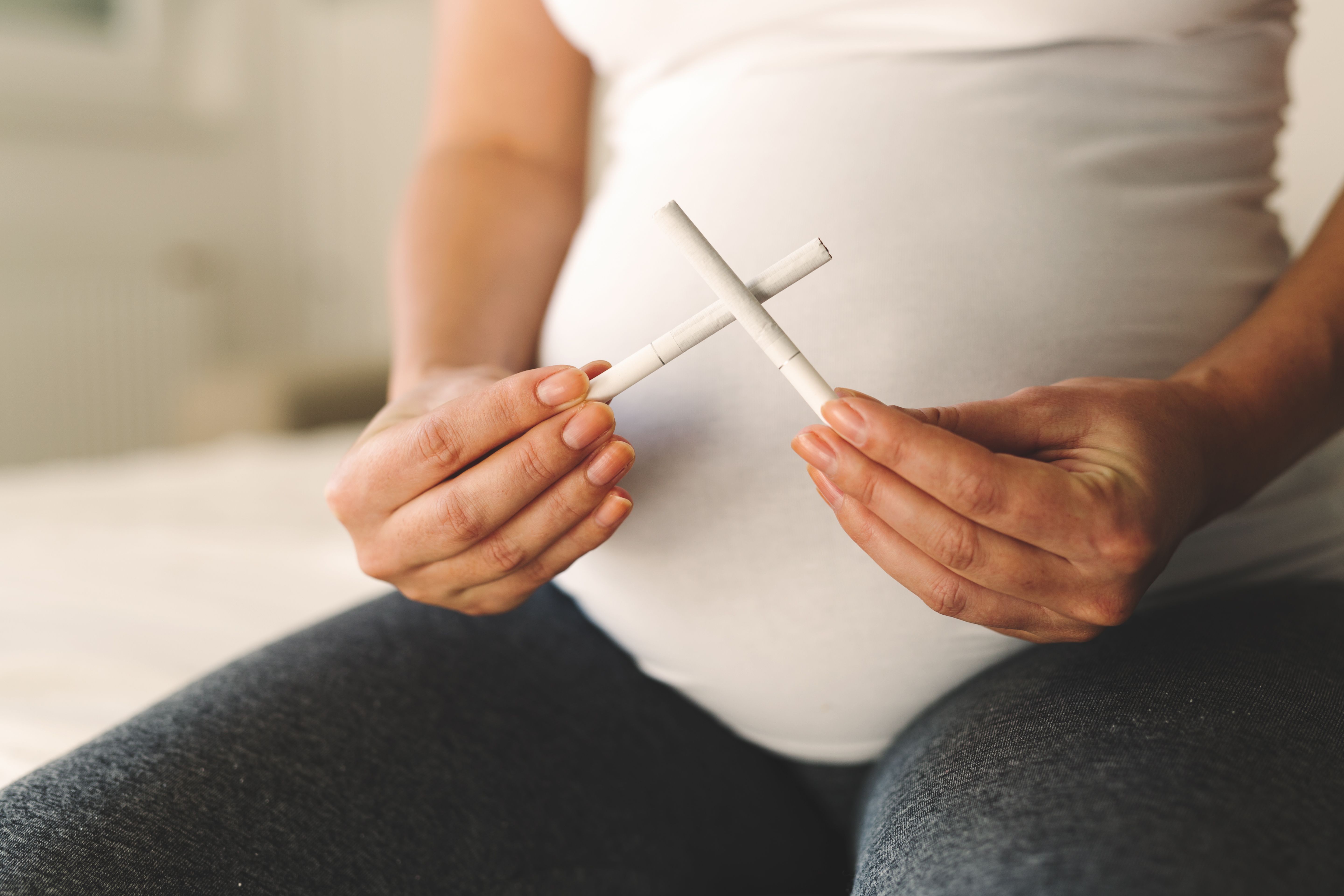 Pregnant Woman Pondering Cigarettes | image credit: NDABCREATIVITY - stock.adobe.com