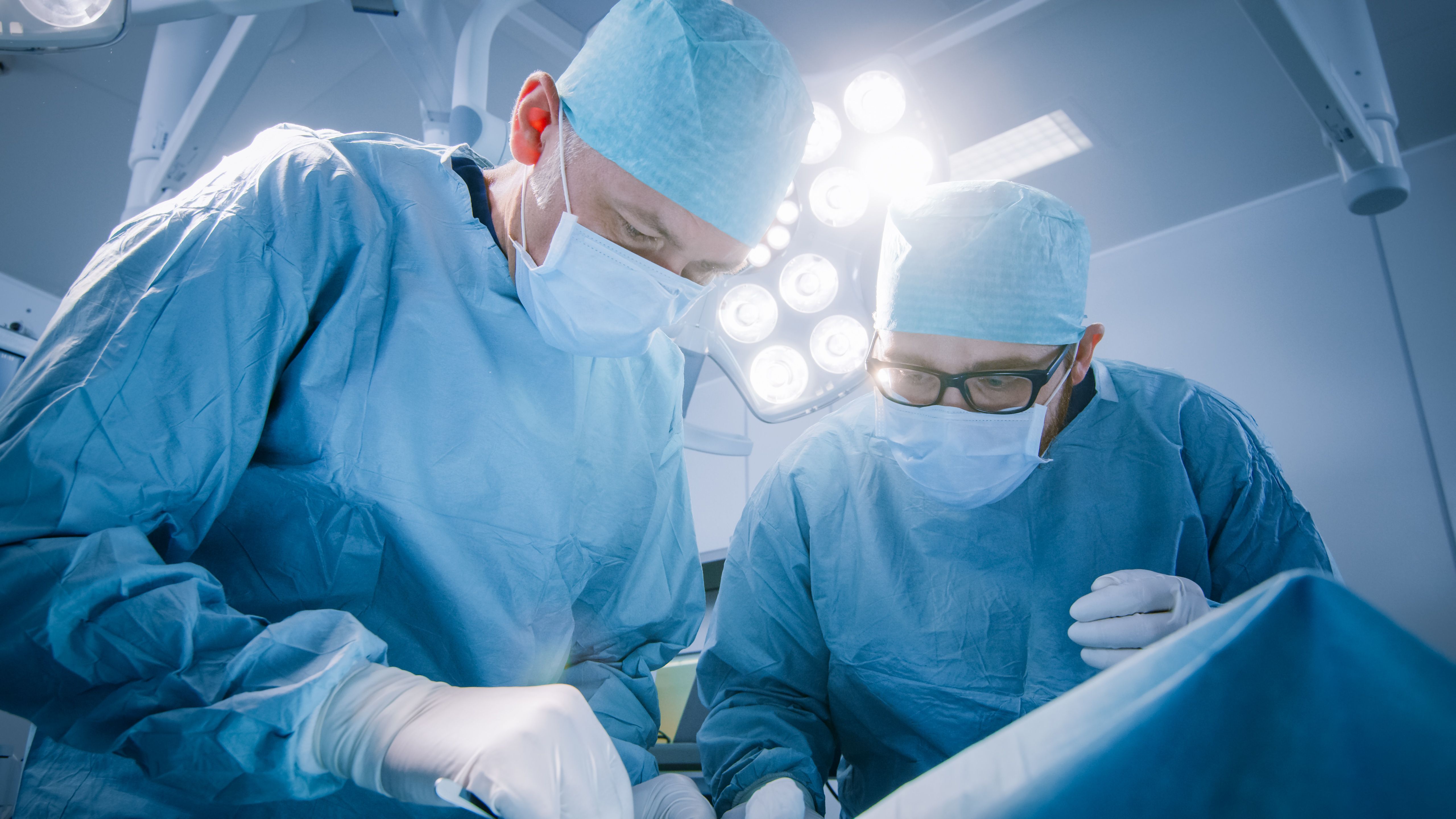 2 male surgeons operating on patient | Image Credit: Gorodenkoff - stock.adobe.com