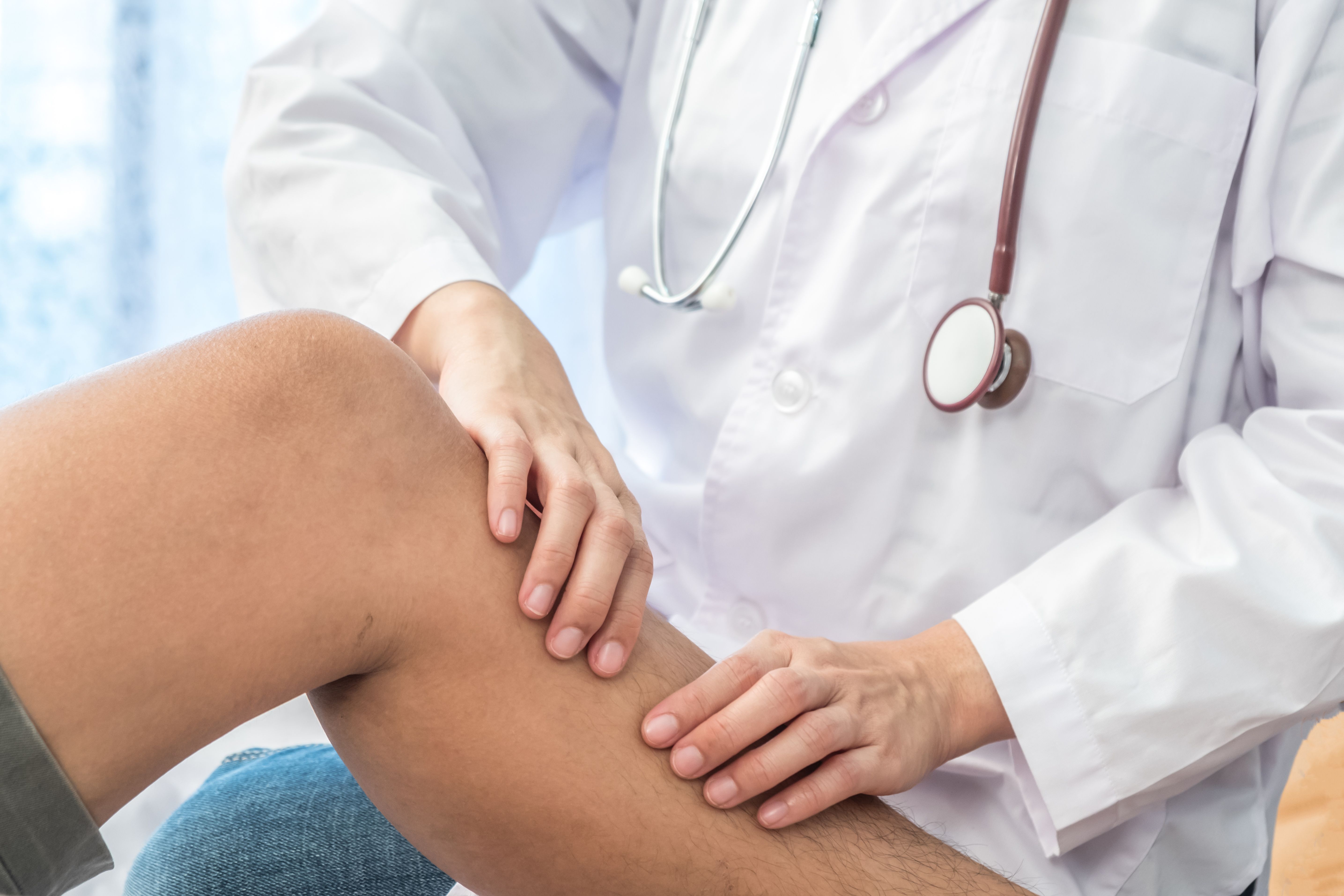 A Doctor Examines a Patient's Leg