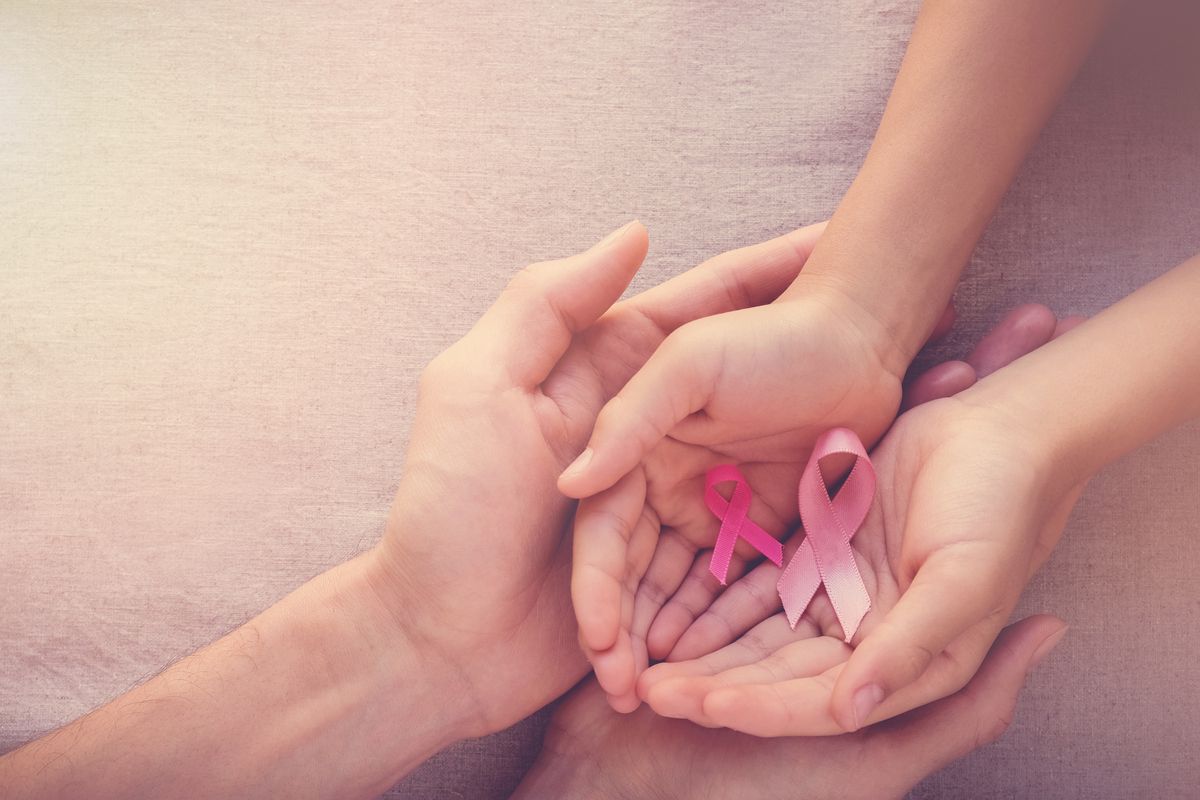 Hands holding pink breast cancer ribbons