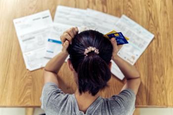 Person sitting at a table with lots of paperwork in front of them. | Image credit: Kawee - stock.adobe.come.jpeg