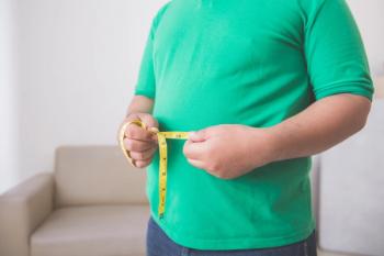 man holding measuring tape around waist