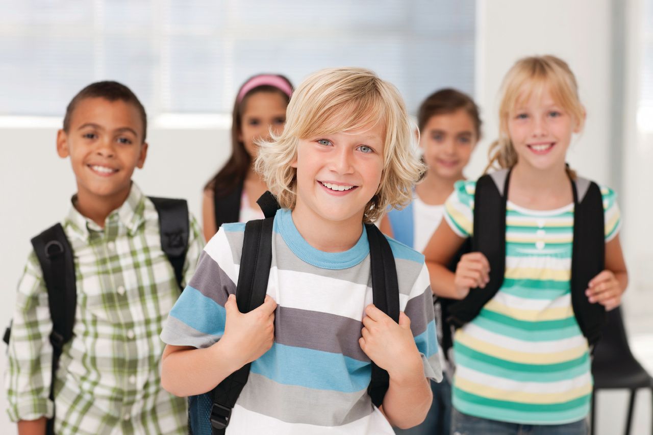 children with backpacks smiling 