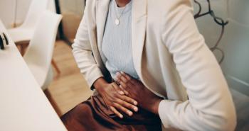 Woman in the office with endometriosis | Image credit: KayExam/peopleimages.com - stock.adobe.com