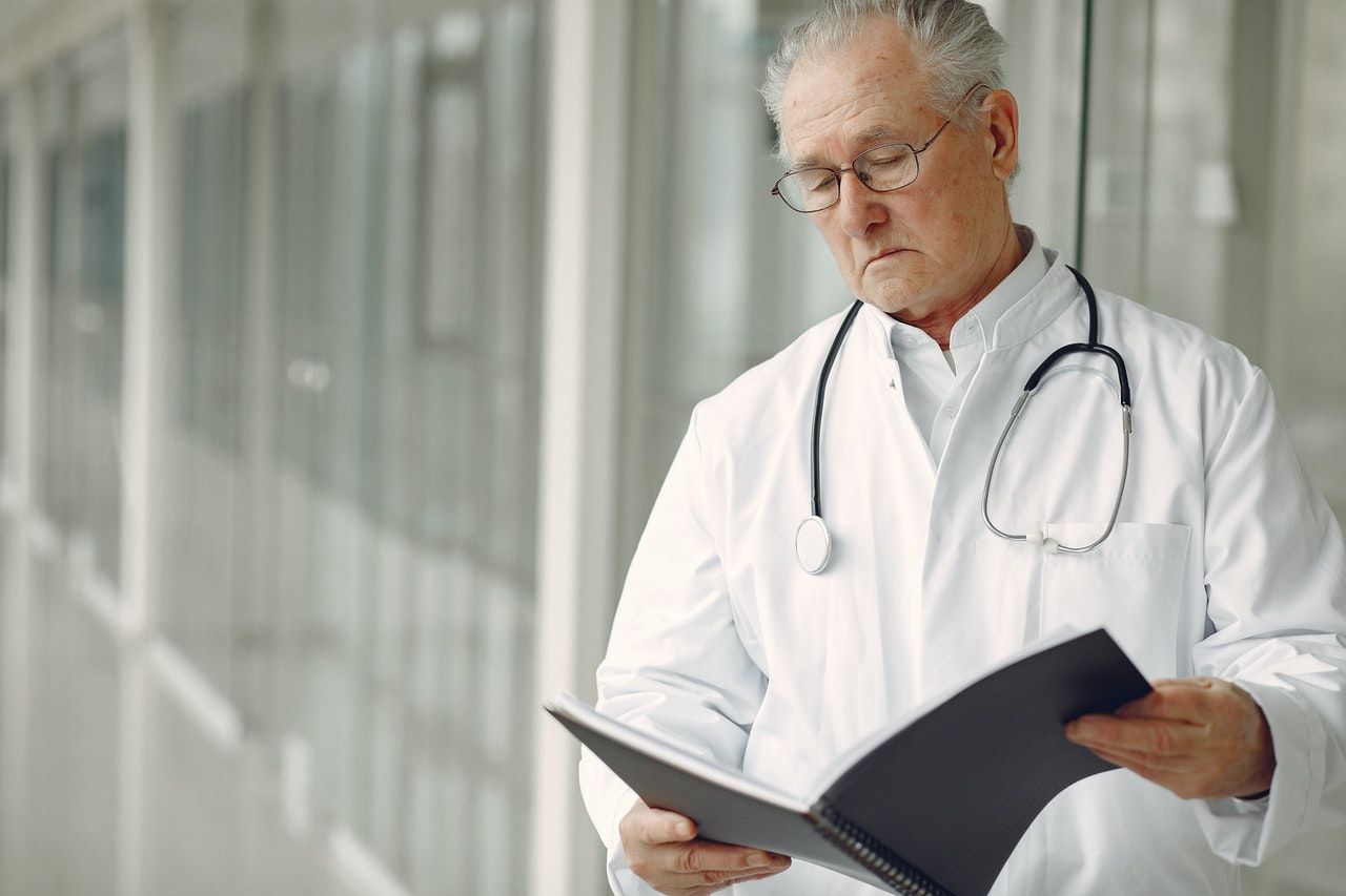 Doctor reading findings in a notebook.