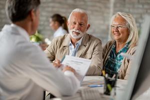Senior couple discussing insurance with doctor | Image Credit: © Drazen - stock.adobe.com
