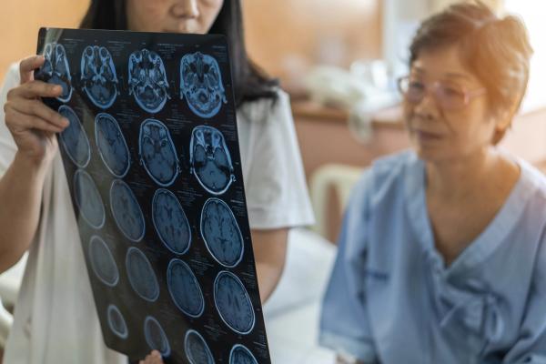 Patient and doctor looking at brain imaging. | Image Credit: Chinnapong – stock.adobe.com