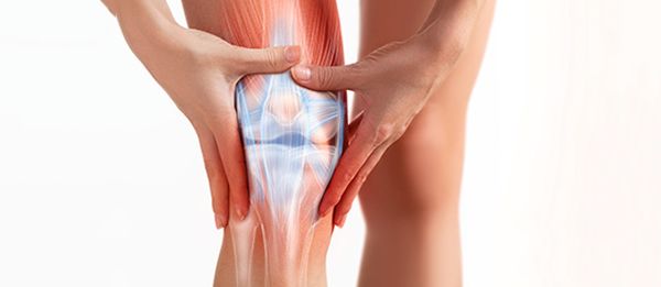 Image of partially exposed knee that is inflamed with persons hands rubbing it due to pain.| Image Credit: BigBlueStudio - stock.adobe.com