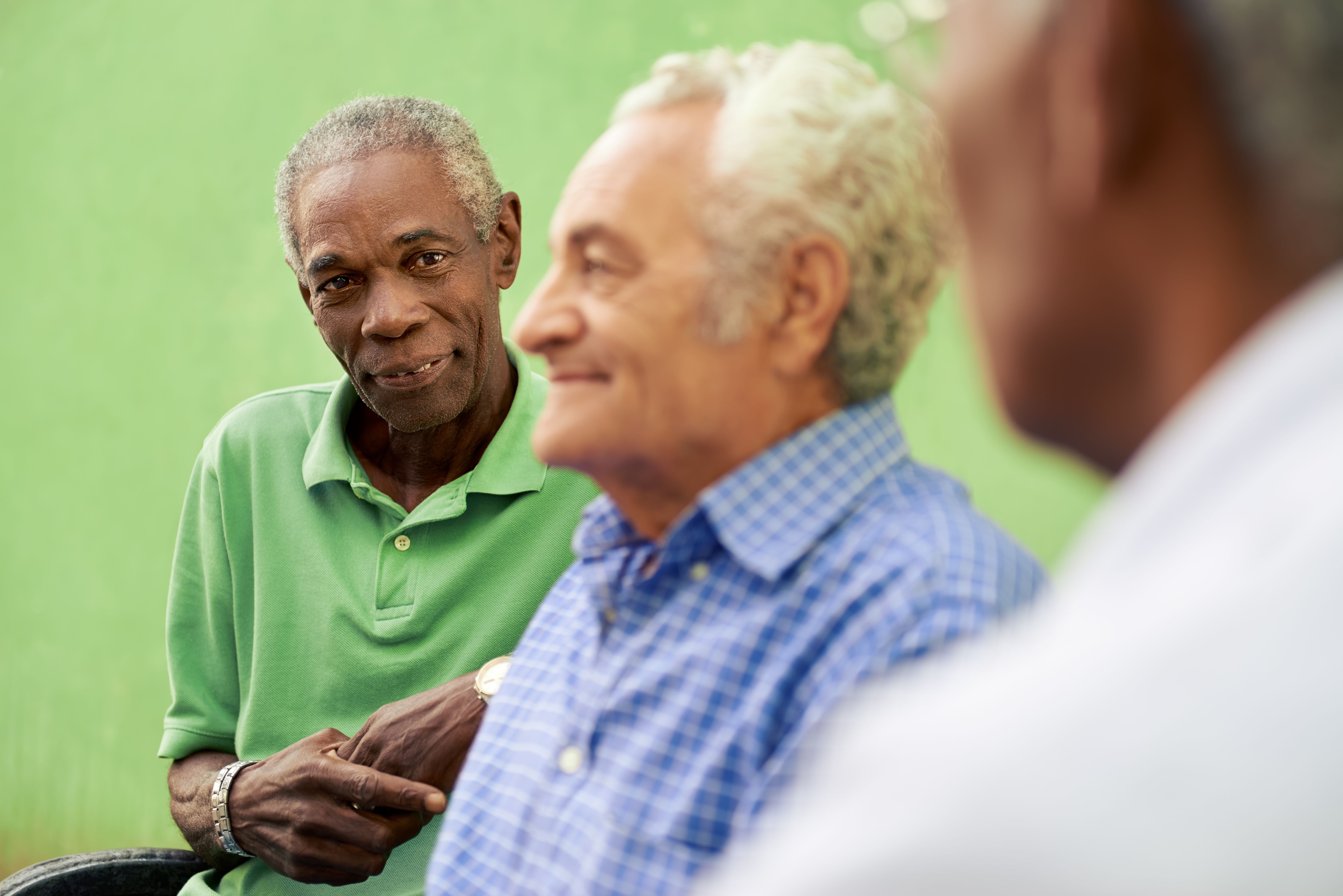 bunch of older men sitting next to each other with 1 black man looking at the camera