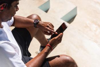Man sitting down wearing smart watch and checking phone | Image credit: sorapop – stock.adobe.com