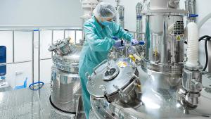 Pharmaceutical factory woman worker in protective clothing operating production line in sterile environment | Image credit: © Ivan Traimak - © Ivan Traimak - stock.adobe.com 
