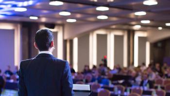 Speaker giving a talk at a corporate business conference. Audience in hall with presenter in front of presentation screen. Corporate executive giving speech during business and entrepreneur seminar. | Image credit: © Right 3 - © Right 3 - stock.adobe.com