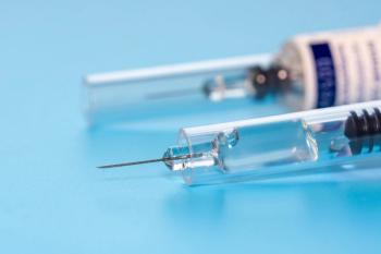 Close-up of two prefilled syringes on a light blue surface, one in focus with a clear barrel and exposed needle and a labeled syringe blurred in the background. | Image Credit: © omar - stock.adobe.com