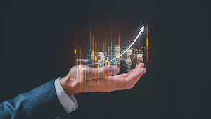 investment and finance concept, businessman holding virtual trading graph and blurred coins on hand, stock market, profits and business growth. | Image credit: © cherdchai - © cherdchai - stock.adobe.com
