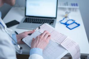 Cardiologist reviewing EKG results, a diagnostic tool used in evaluating cardiac conditions like ATTR-CM. | Image Credit: © Elizaveta - stock.adobe.com