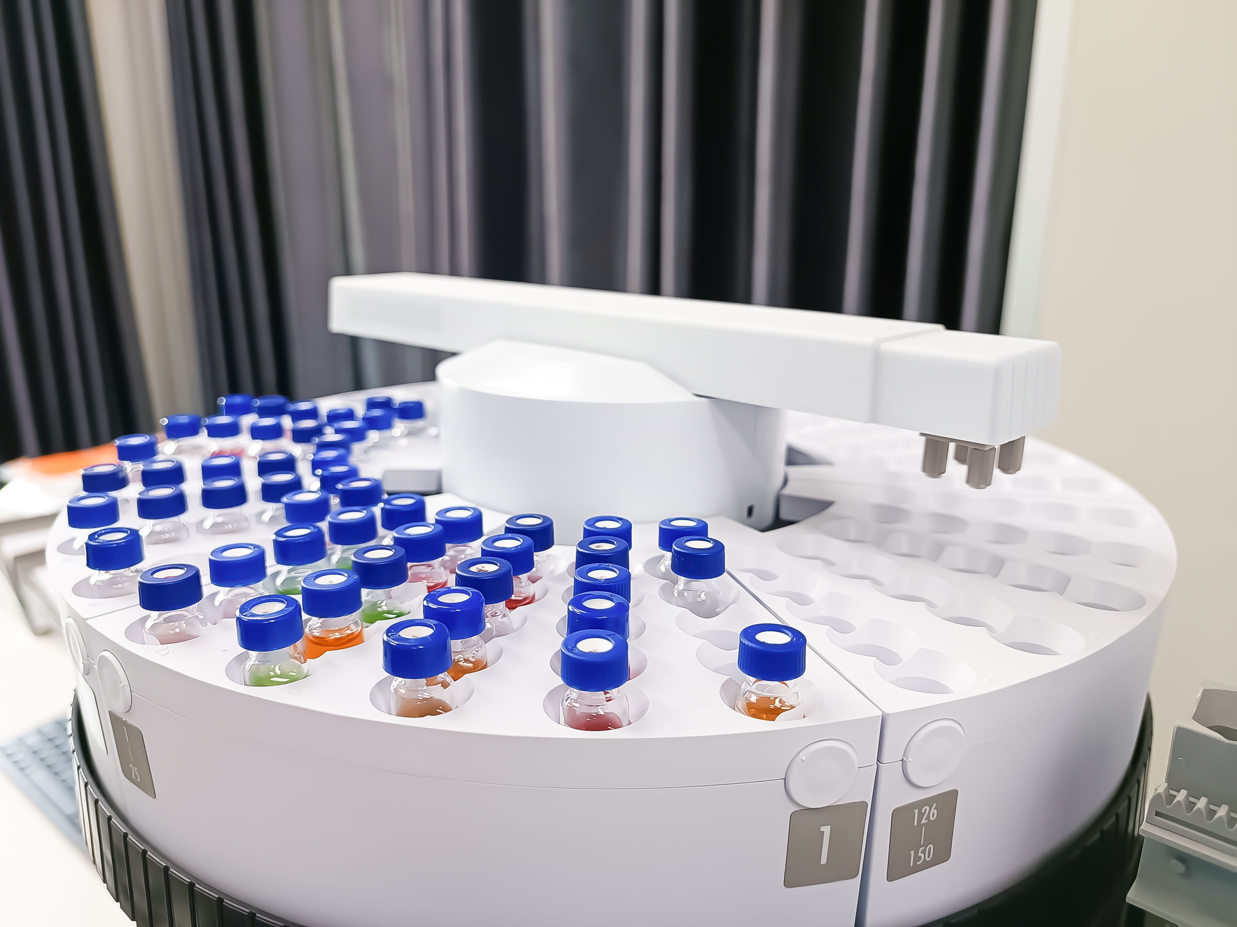 Photograph of an automated laboratory sample handling system with vials in an autosampler carousel. | Image Credit: © MJ iceberg - stock.adobe.com