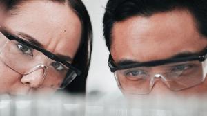 Science, woman and man looking at test tube in laboratory, research in vaccine results and medical innovation. Healthcare, biotech lab analytics and medicine, scientist team in pharmaceutical study. | Image Credit: ©Talia Mdlungu/peopleimages.com – stock.adobe.com