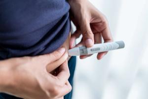 Close-up photograph of a woman administering a subcutaneous injection to her abdomen. | Image Credit: © BJ Day Stock - stock.adobe.com