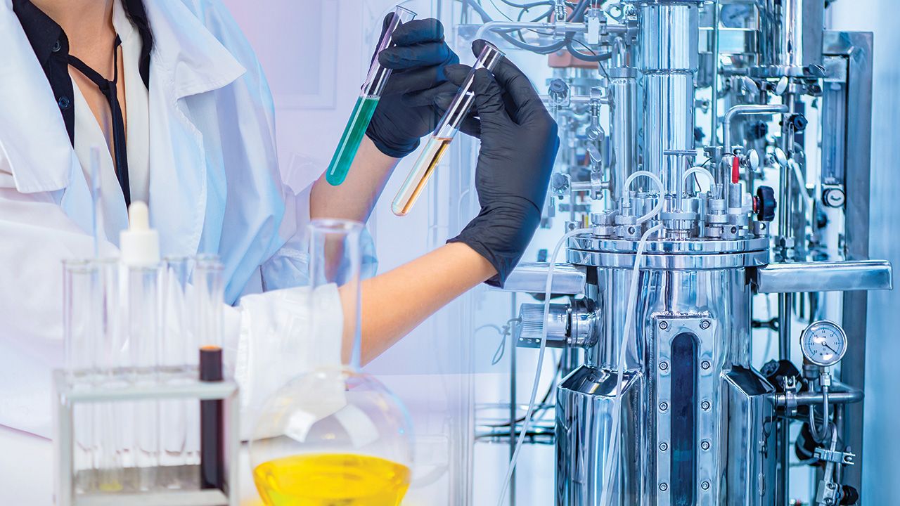 Liquid obtained in the fermentation process. Microbiologist with test tubes in his hands. Chemical laboratory equipment. Laboratory bioreactor for the production of vaccines. Pharmacology. | Image Credit: © Grispb –  © Grispb - stock.adobe.com