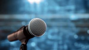 Public speaking backgrounds, Close-up the microphone on stand for speaker speech at seminar room with technology light background and blur bokeh. | Image credit: © Eakrin - © Eakrin - stock.adobe.com